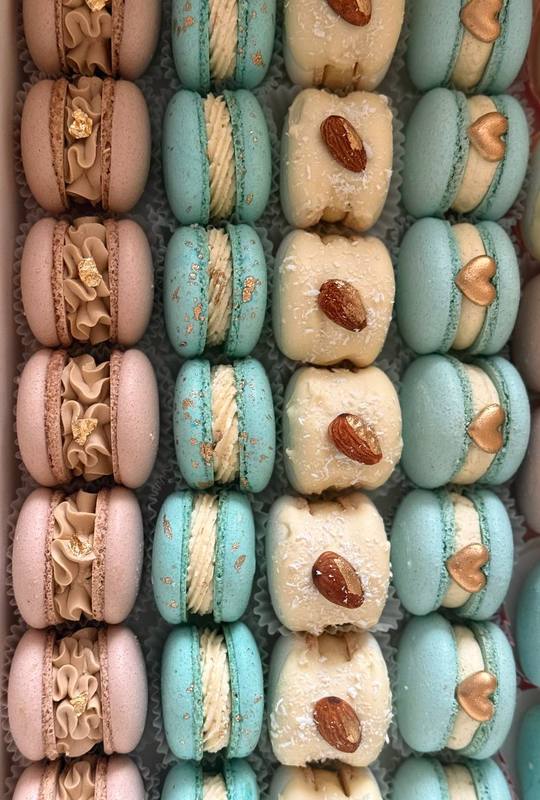 Рожеві макаронс із золотом, м'ятні, мигдалеві з кокосом та блакитні з серцями — крупний план