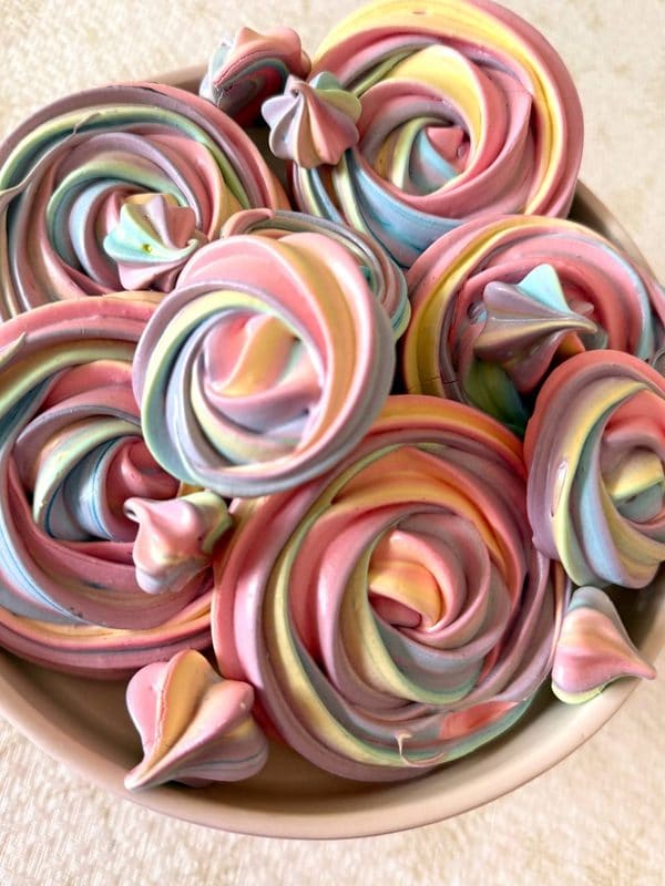 Різнобарвні меренгові троянди з пастельними завитками крупним планом у мисці